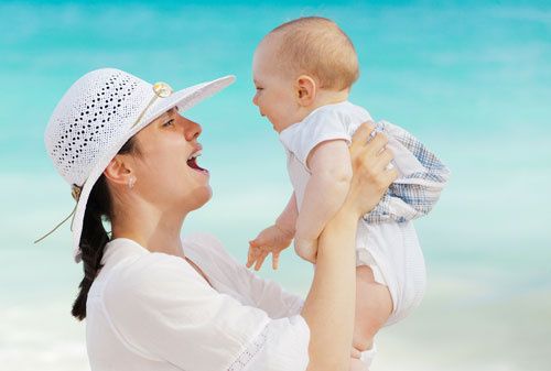 Mother lifting young baby
