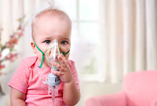 Baby with an inhalation mask on their face