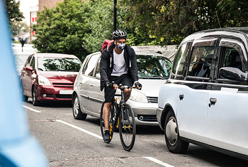 Commuter on a bike wearing a pollution mask