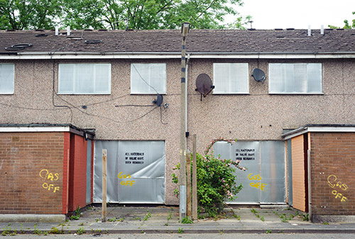 Abandoned terraced houses with metal shutters