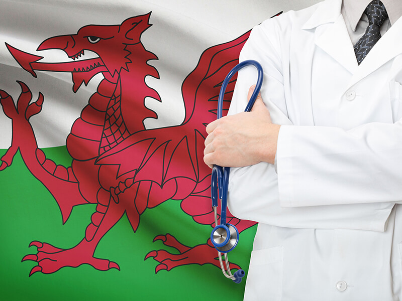 A doctor standing in front of the welsh flag
