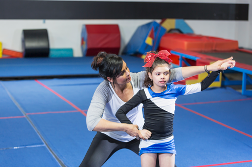Coach helping girl on cheerleading team
