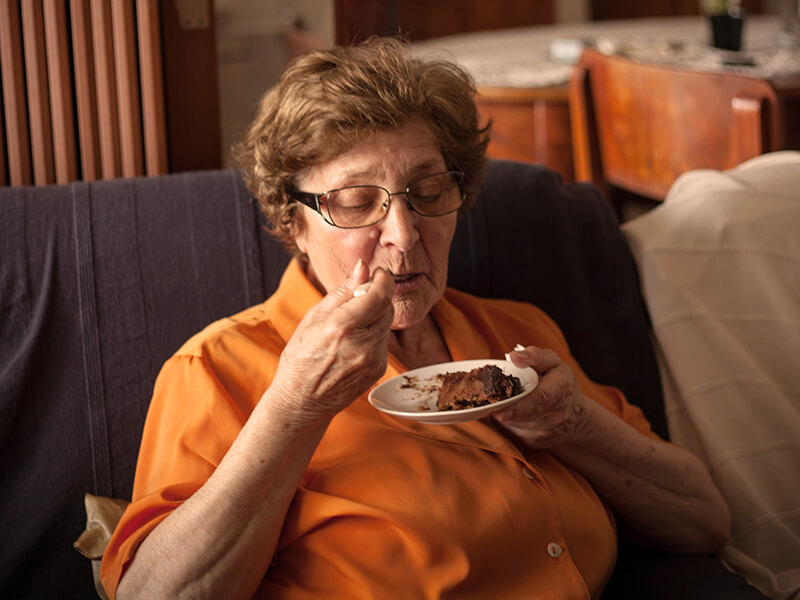 Older lady eating cake