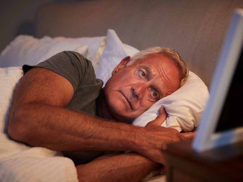Old man in bed looking at picture