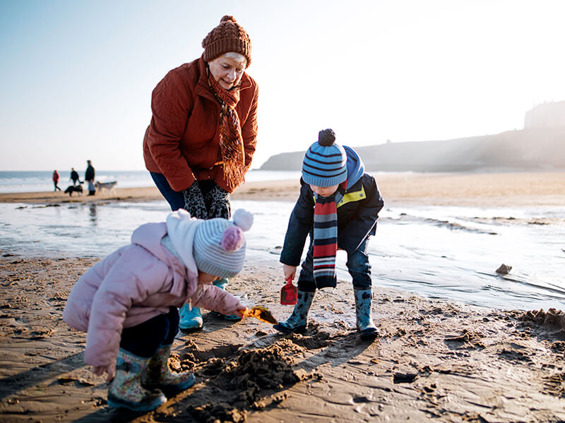 grandmother and grandchildren playing on the beach