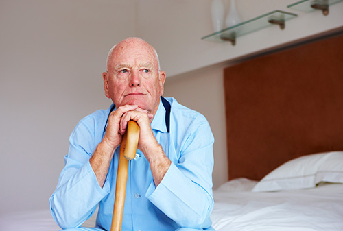 Old man resting hand on stick
