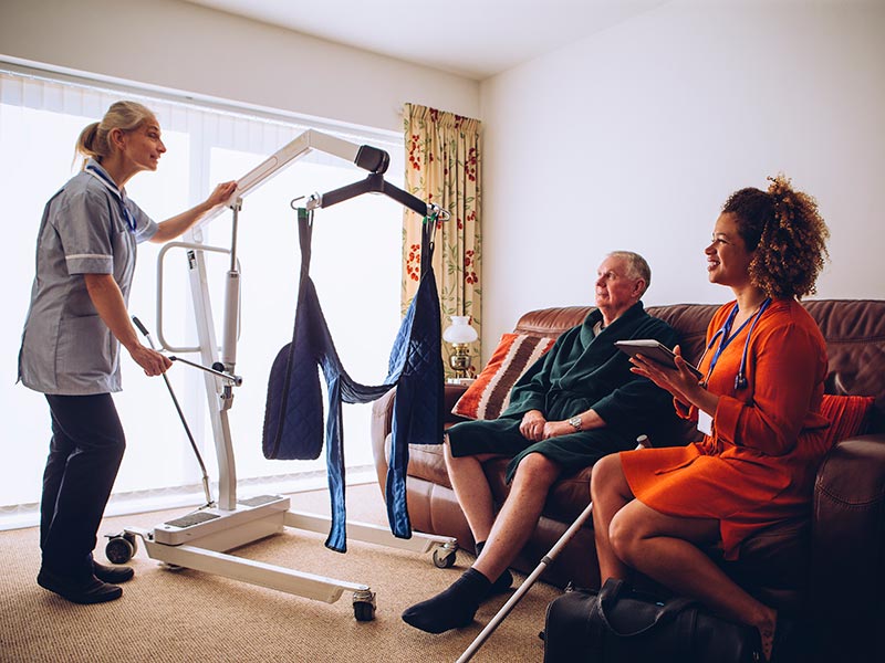 Homecare workers demonstrating a hoist