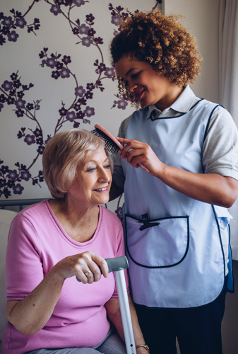 Carer brushing patients hair
