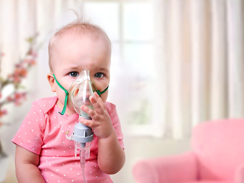 A young girl wearing a respirator