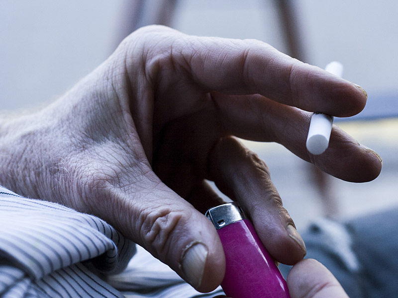 Hands holding a cigarette and lighter