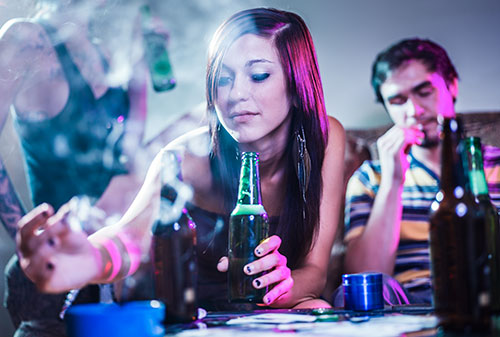 A young woman smoking and drinking