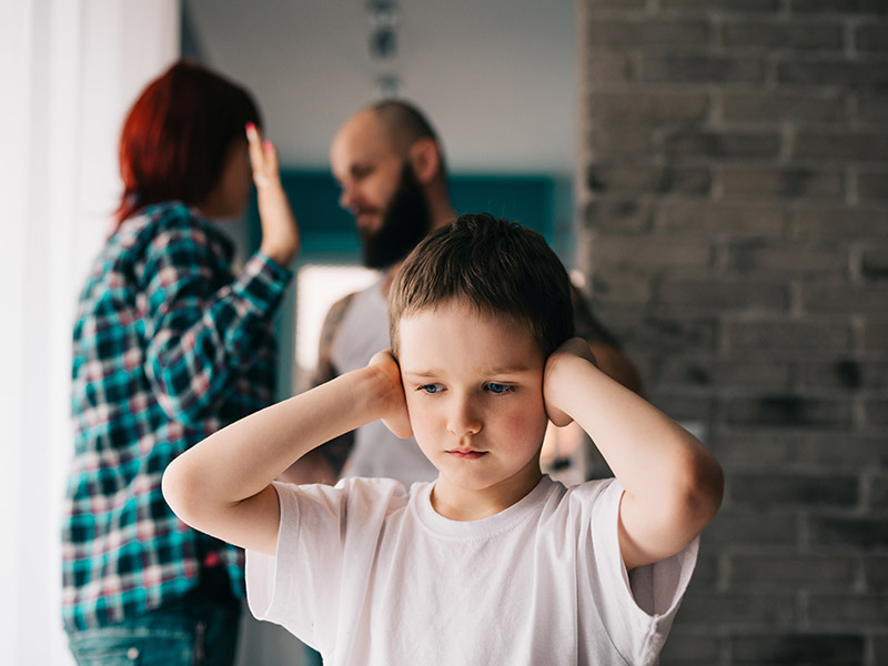 A couple arguing in front of a child