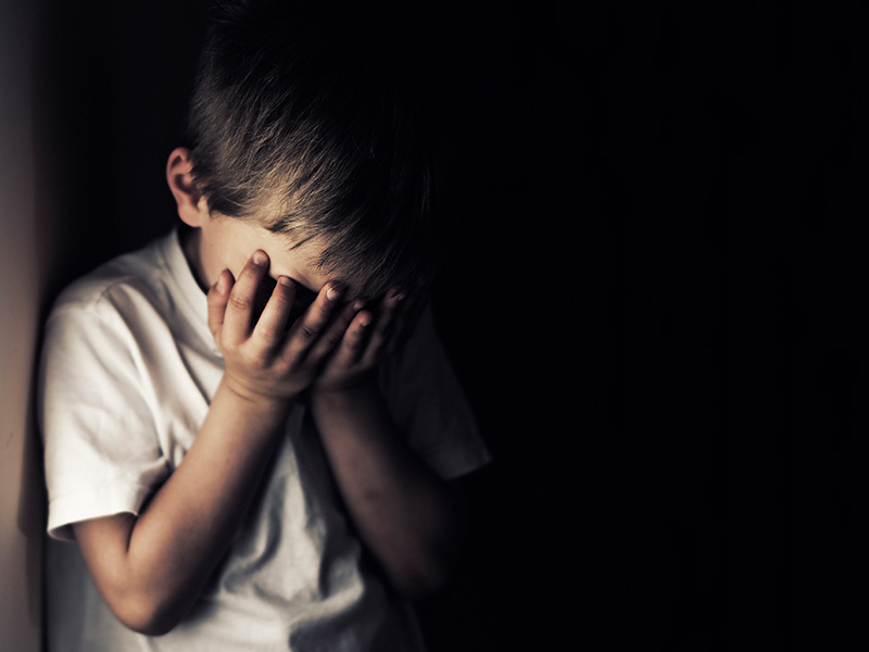 A neglected child with his head in his hands