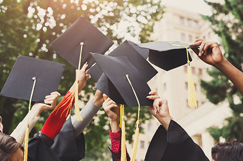 Graduates throwing graduation caps