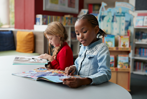 Schoolgirls reading books in school library
