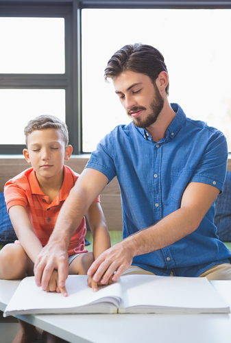 Teacher assisting blind student in library
