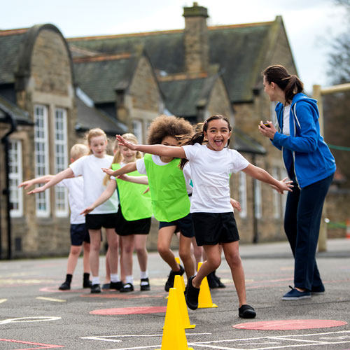 young children having a PE lesson in the schoolyard