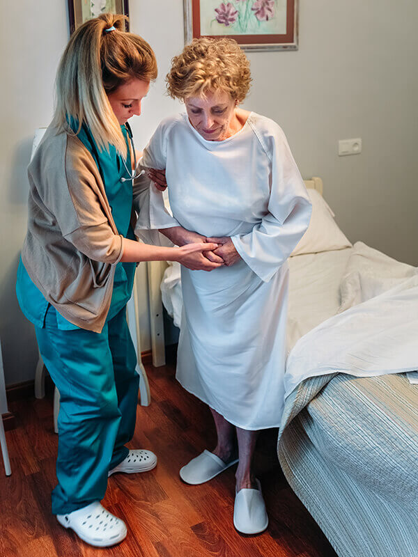 A caregiver helping an elderly woman
