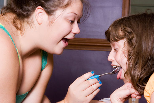 Carer feeding disabled child