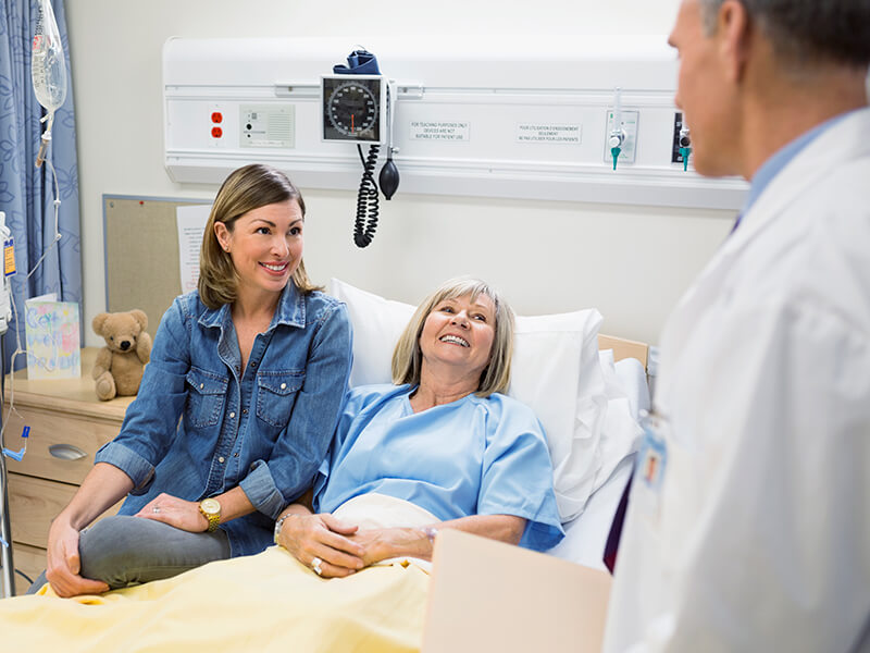 A doctor speaking with a patient and relative