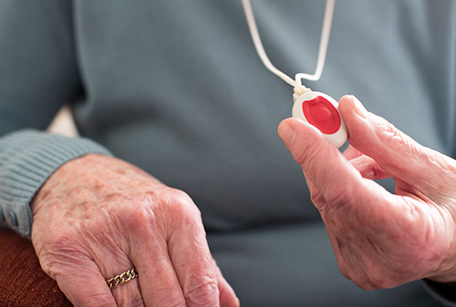 elderly woman holding alarm