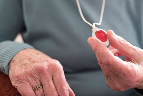 Elderly woman holding alarm